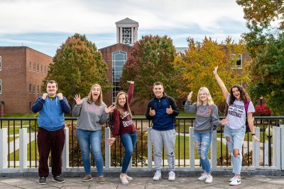 A group of students posing in front of the bell tower