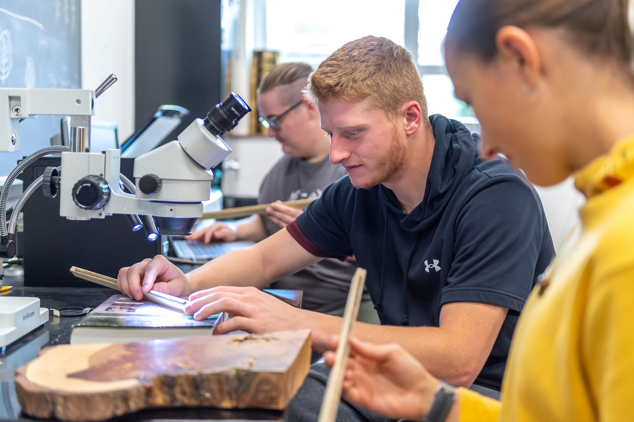 Three students working in an environmental geosciences lab