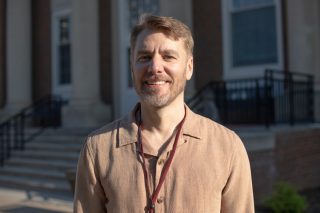 A photo of Aaron Burton standing in front of the J. Franklin Marsh Library at Concord University