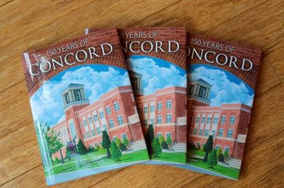 A stack of three Concord University 150 anniversary commemorative books