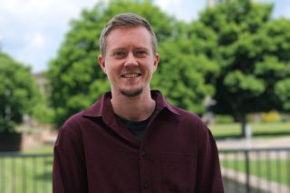 A photo of Cade Brown standing in front of the J. Franklin Marsh Library at Concord University