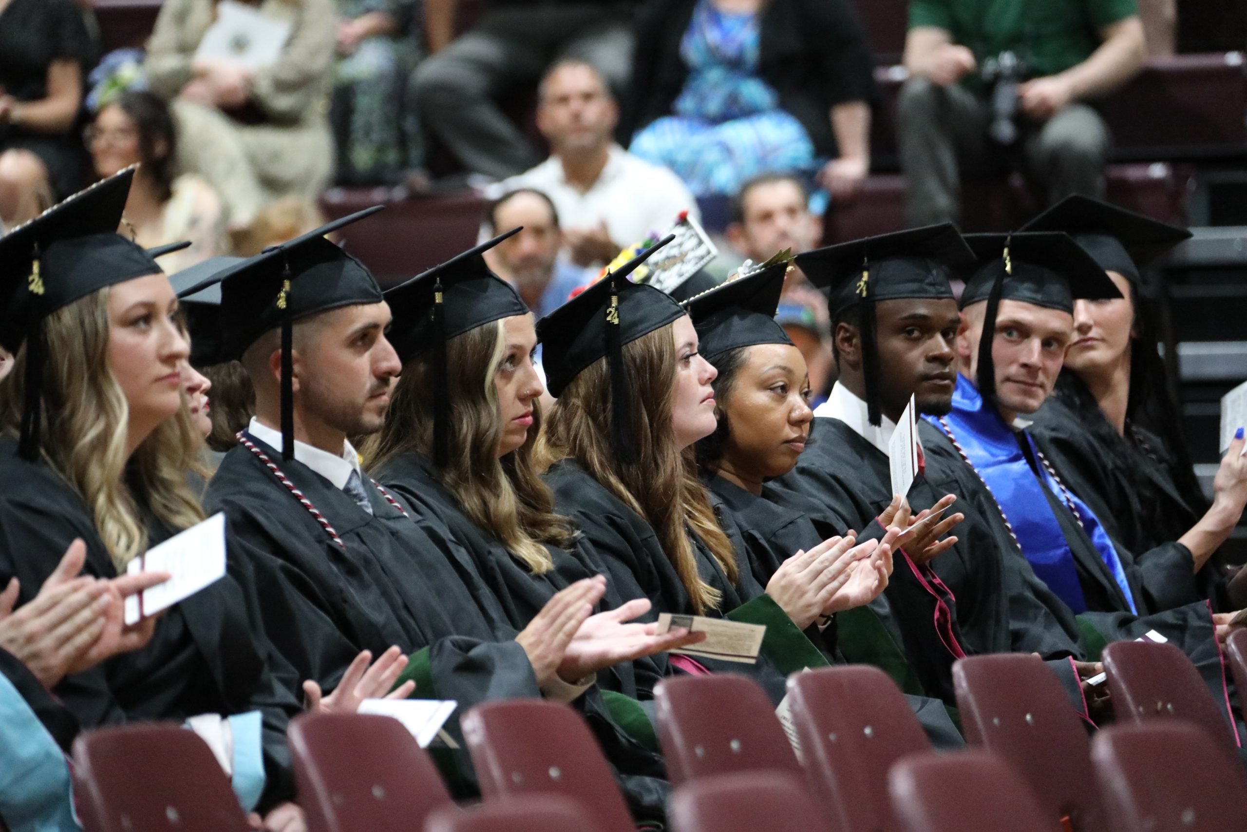 A photo of Concord University graduates clapping during the commencement ceremony