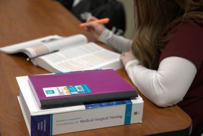 A nursing student taking notes during lecture