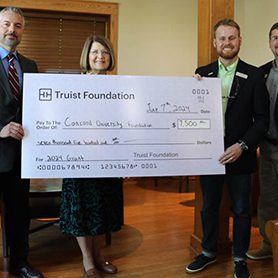 Andrew Sulgit and Dr. Kendra Boggess standing next to representatives from the Truist Foundation holding a giant check for Concord University for seven thousand five hundred dollars