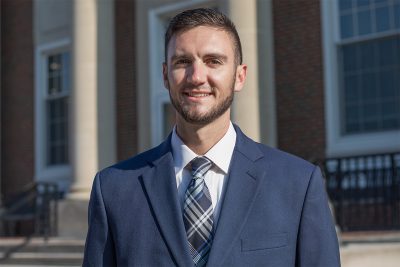 A photo of Ryan Weikle in front of the J. Franklin Marsh Library at Concord University