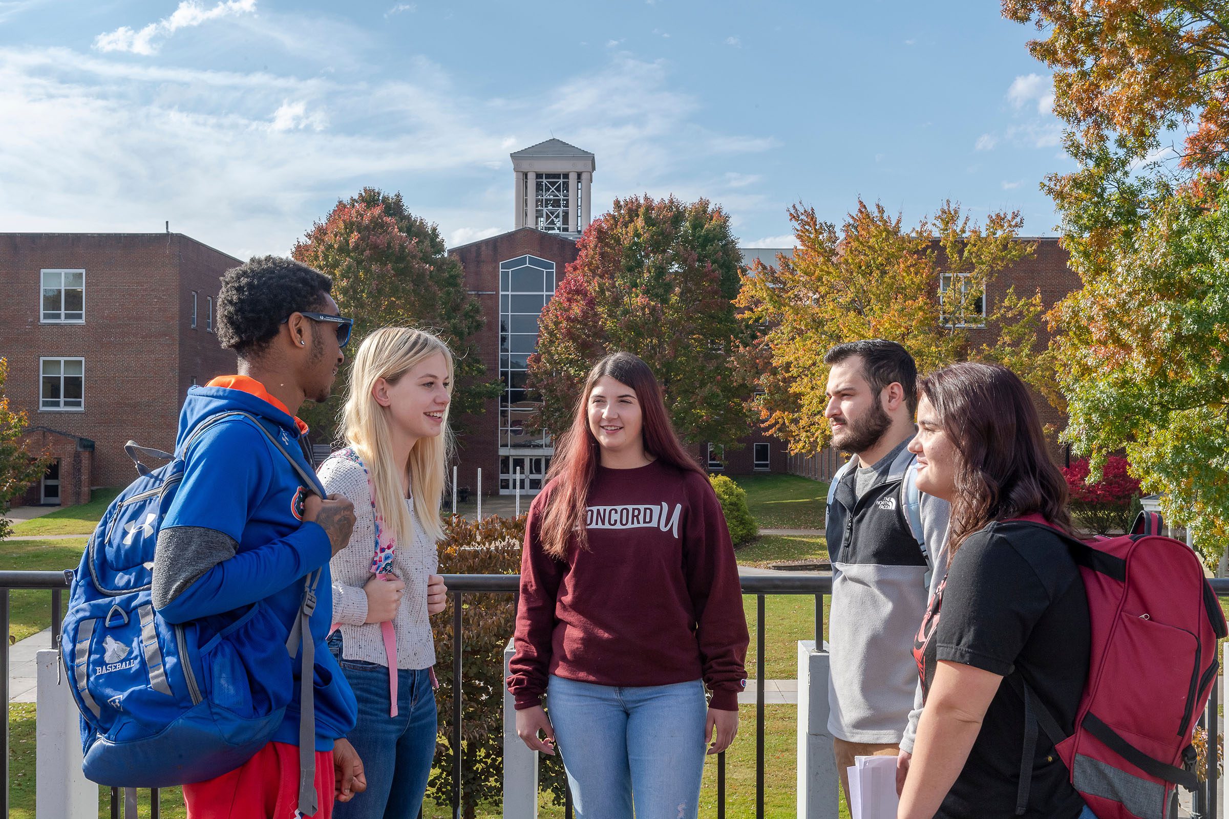 A group of students standing and talking on the Alexander Fine Arts Center balcony