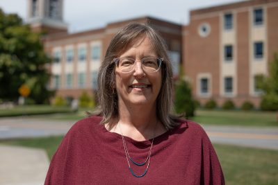 A photo of Dr. Tracy Luff in front of Marsh Hall