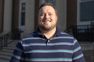 A photo of Zac Thomas standing in front of the J. Franklin Marsh Library at Concord University